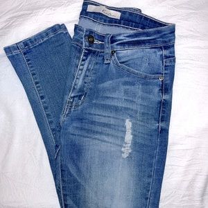 Gently wore, stylish blue jeans. Mid-high waisted. A few small holes for detail